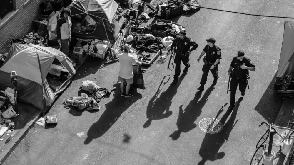 San Francisco Police Department officers walk by a homeless tent encampment along Willow Street in the Tenderloin district of San Francisco in 2020. | Source: Nick Otto for The Standard